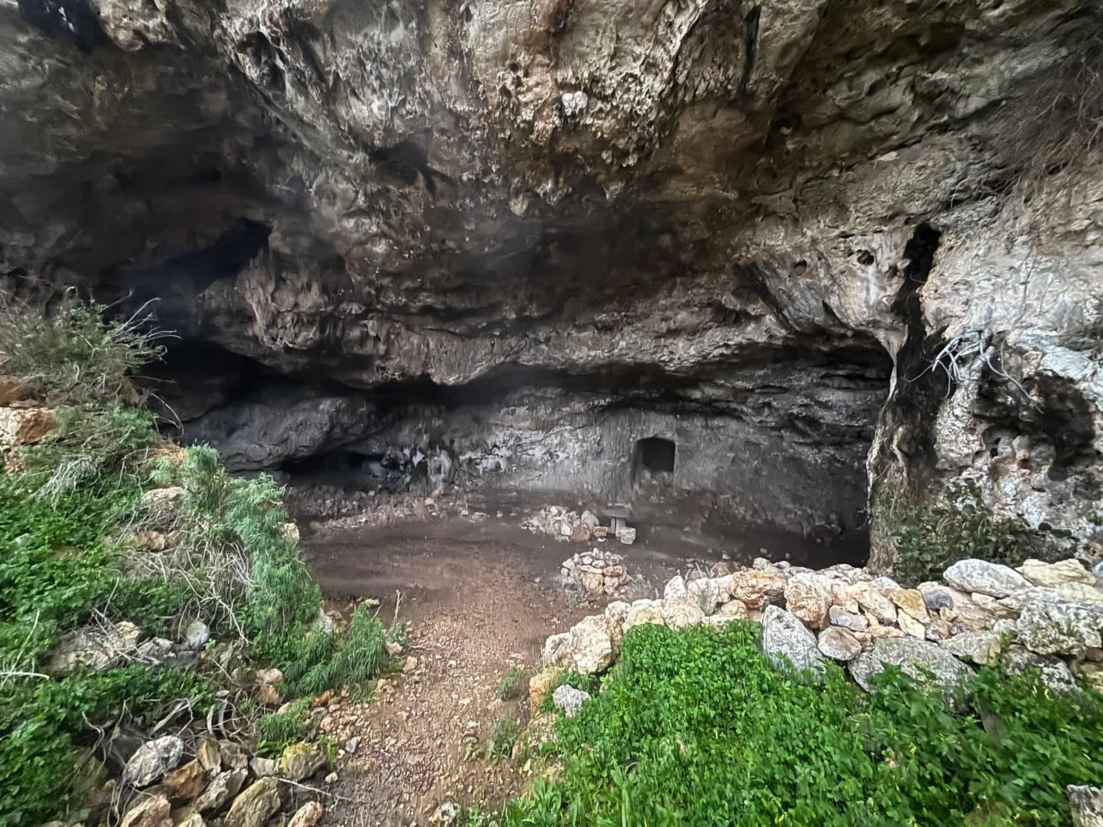 Entrance and limestone surroundings of L-Għar l-Iswed (Black Cave) in Baħrija, Malta