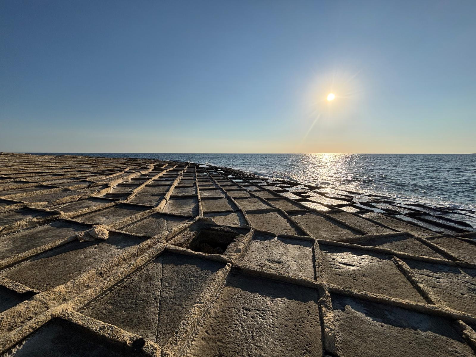 Low perspective view showing the precise alignment and shallow hand-chiseled rims of the salt pans