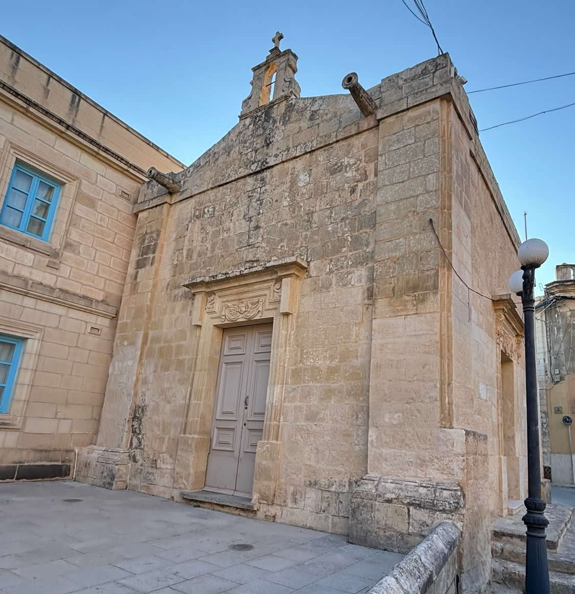 Symmetric front facade of Il-Lunzjata Chapel in Kirkop, showing the stone bell-cot and central portal