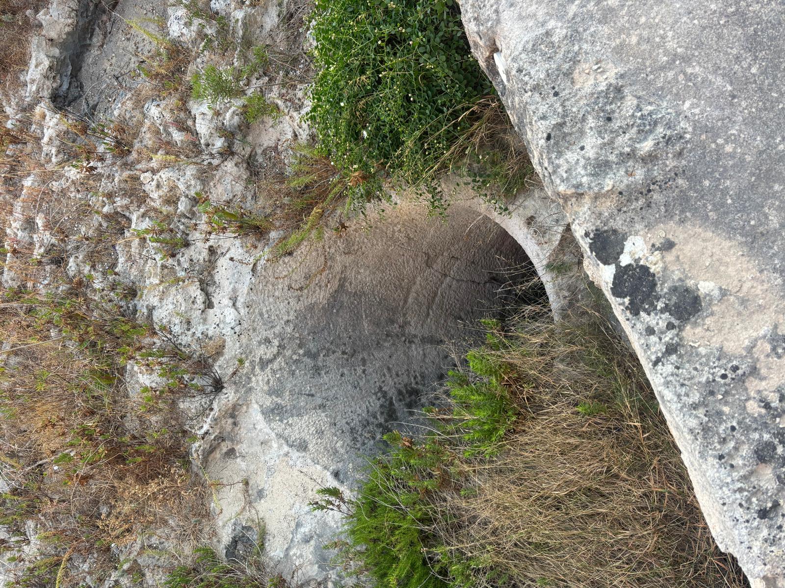 Clear perspective highlighting the transition between raw bedrock cut and the stone masonry of Ximenes Redoubt