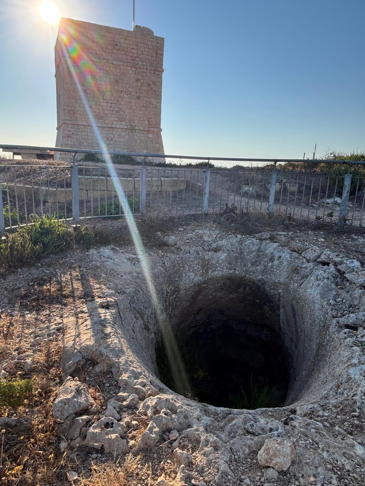 Looking straight down the deep vertical barrel profile of the rock mortar showing internal flora growth