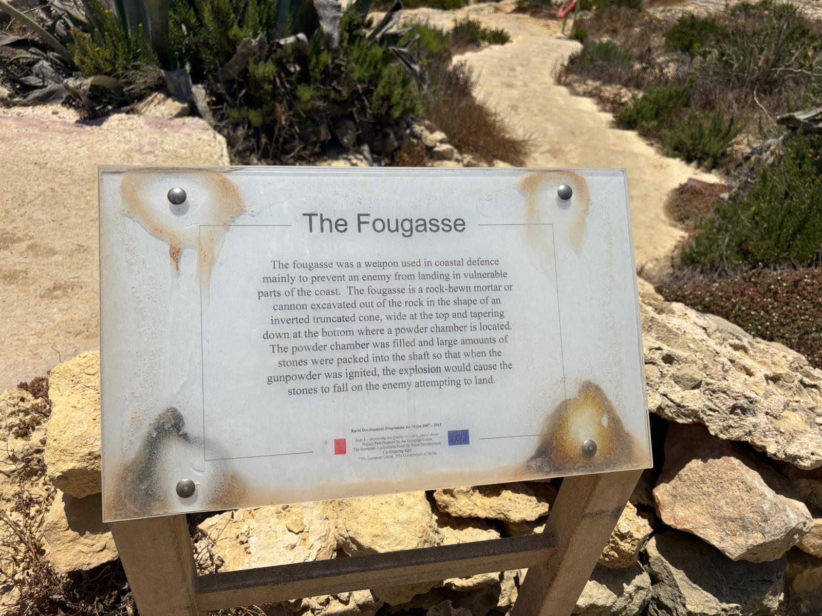 Official heritage information sign titled 'The Fougasse' explaining the weapon's history and design metrics