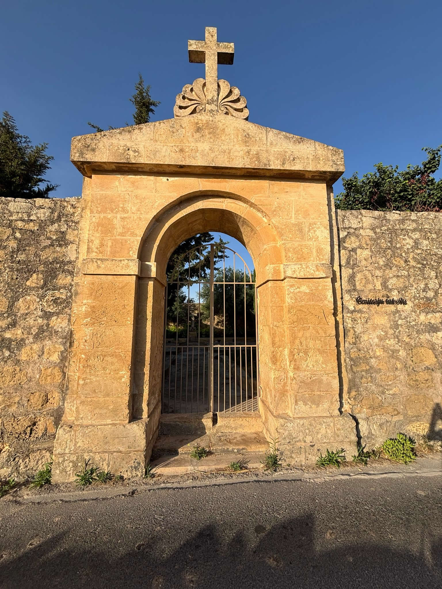 The high limestone rubble walls and boundary marker of Iċ-Ċimiterju tal-Ars in Qrendi