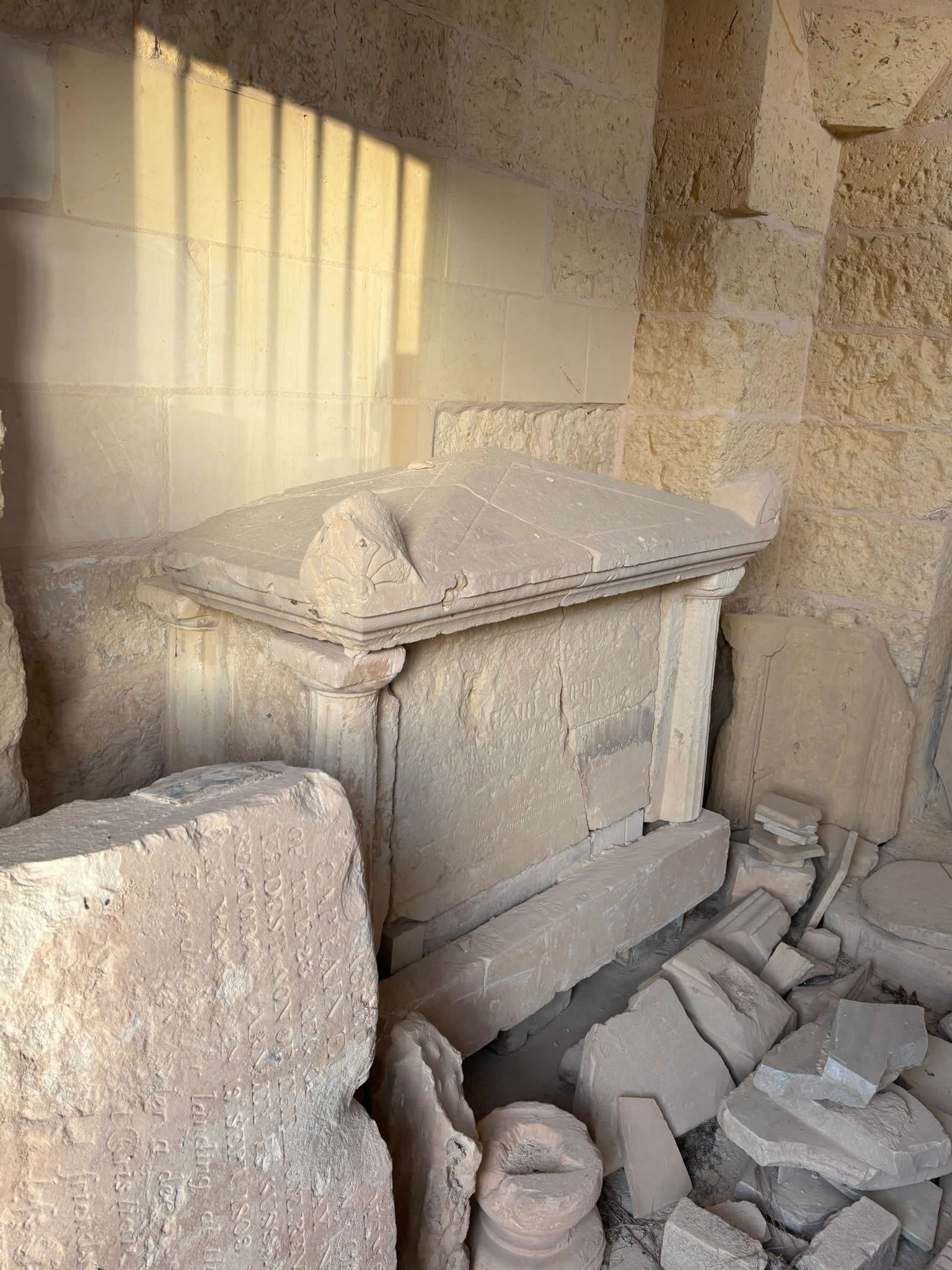 Salvaged classical box-tomb and gabled limestone monuments inside St George Chapel