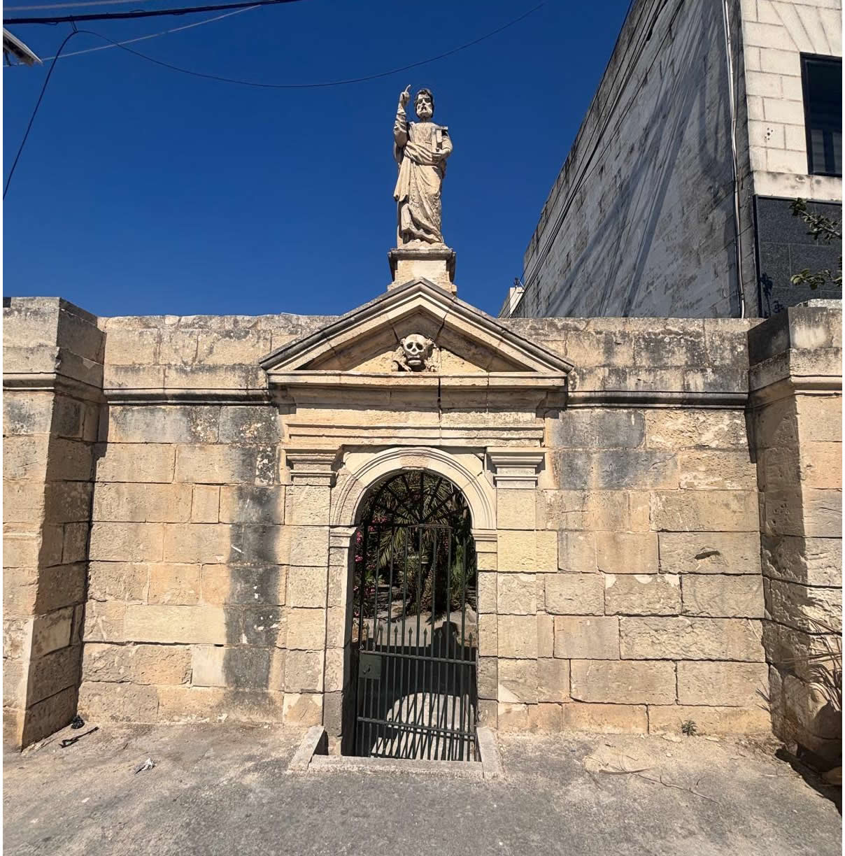 Plague Cemetery Luqa Malta small historic burial site next to modern buildings on Luqa village outskirts