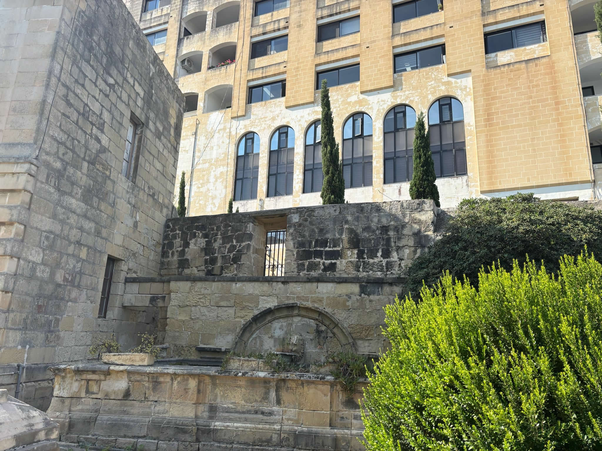 Historic stone gateway and boundary walls of the Jewish section inside Ta Braxia Cemetery