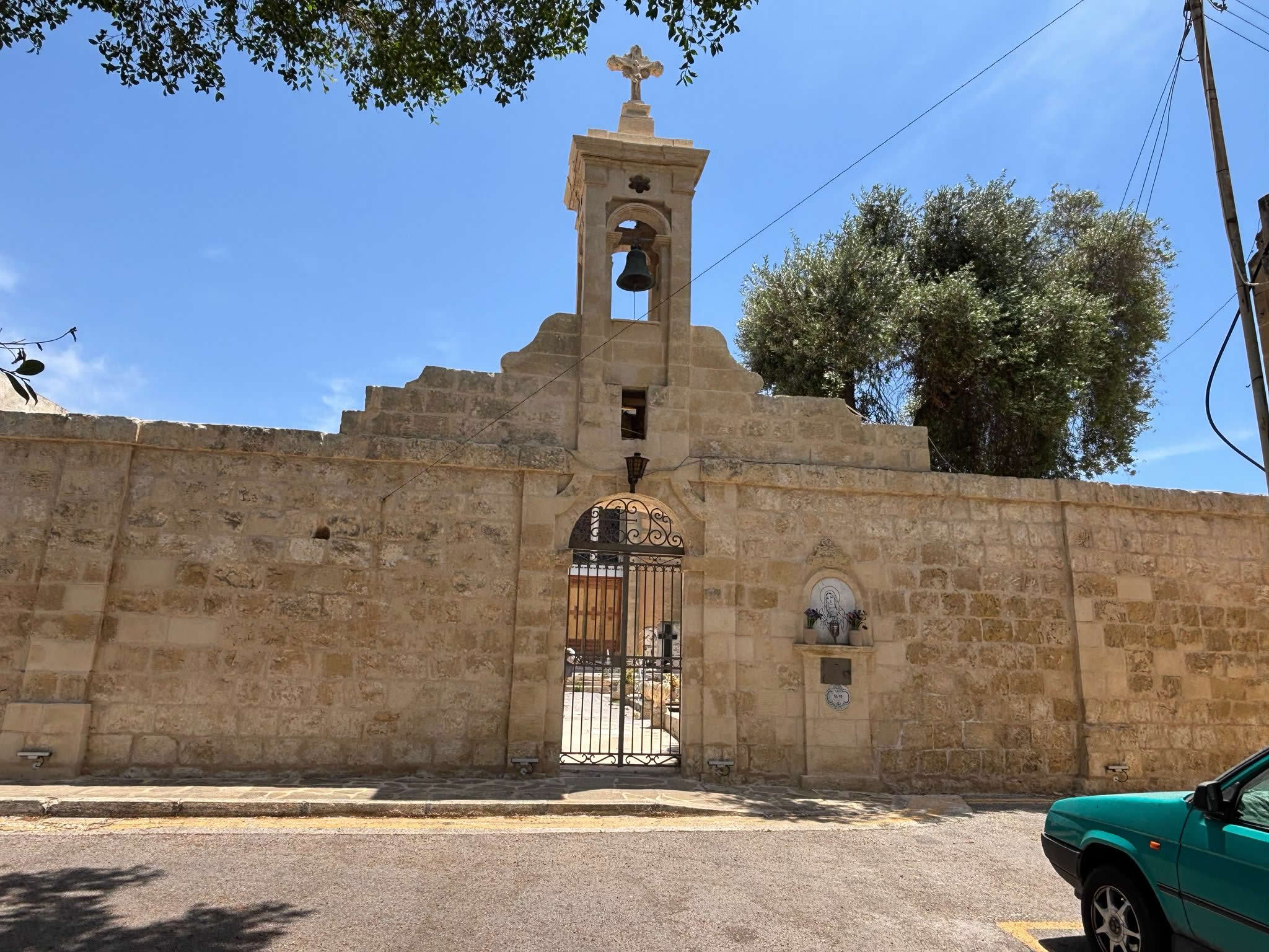 The monumental stone boundary wall and integrated entrance bell-cot of the Tarxien Parish Cemetery