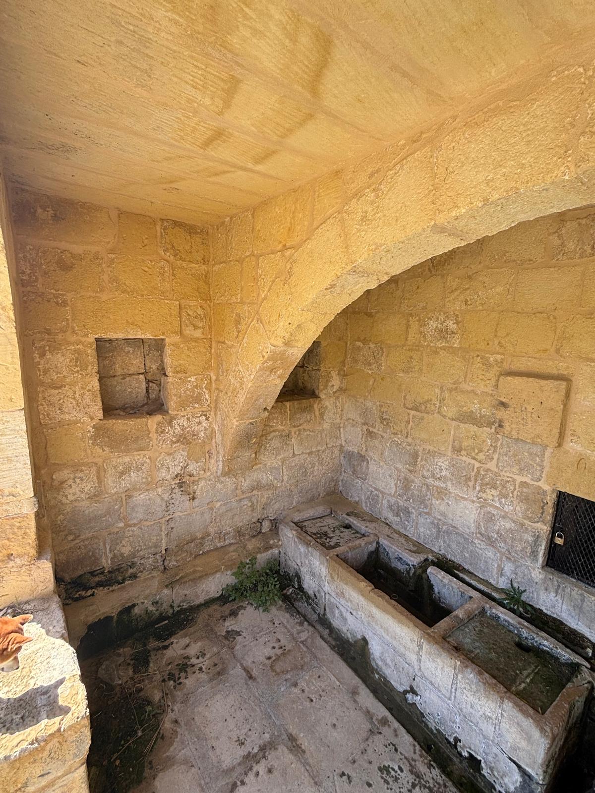 Left side stone vault view showing recessed square storage alcoves in the masonry wall