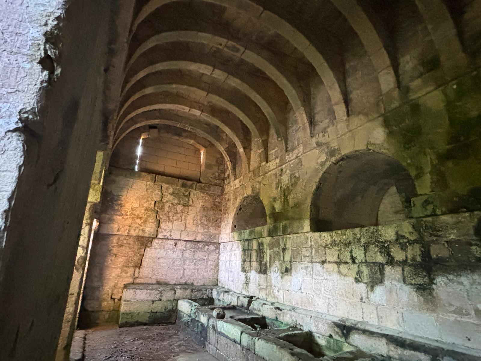 Angled interior shot showing large stone arches and blind wall niches inside the Rabat wash house