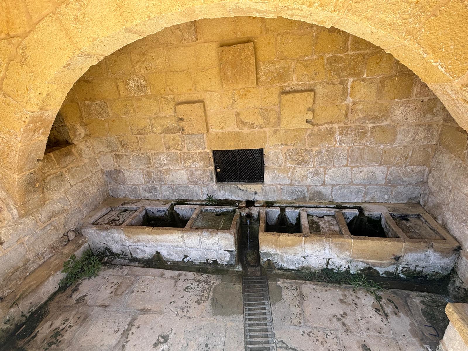 Interior symmetric stone washboards and central drainage trench inside Ghajn Tuta