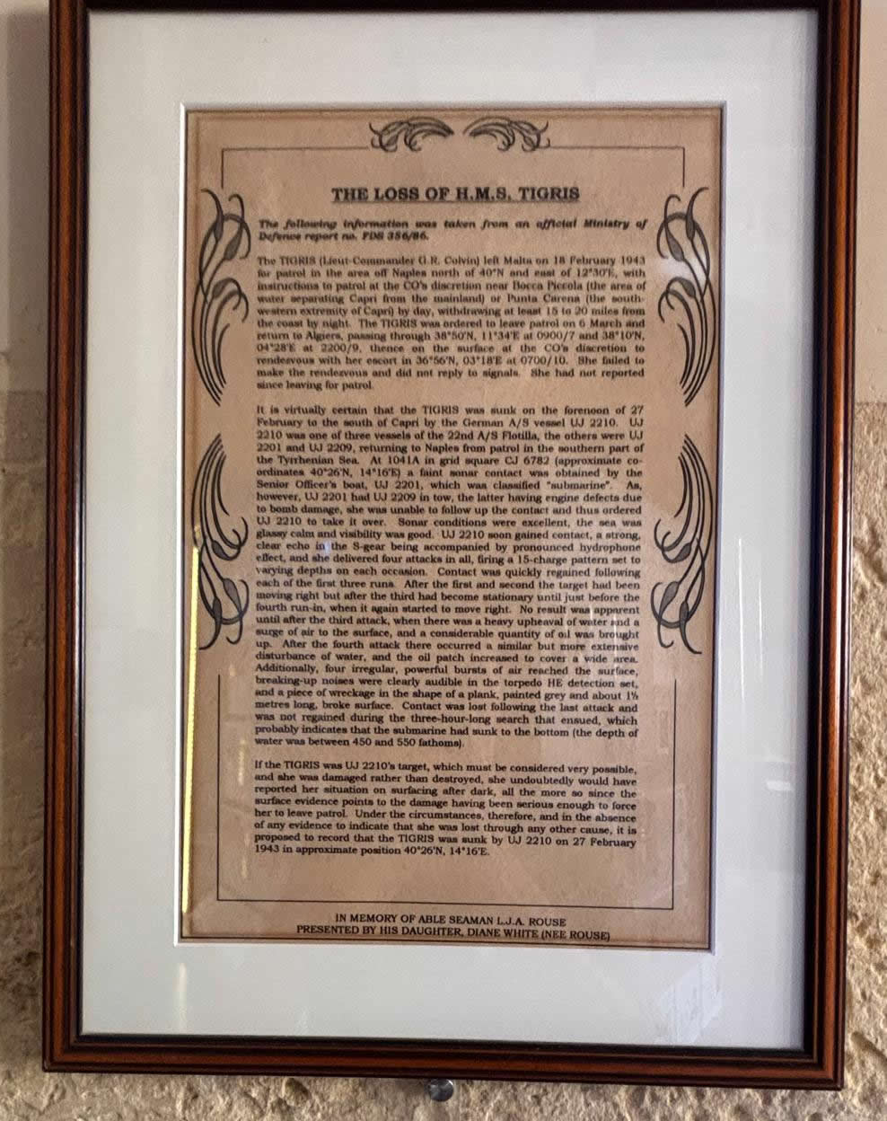 Framed document detailing the official Ministry of Defence report on the loss of HMS Tigris, mounted on a stone wall