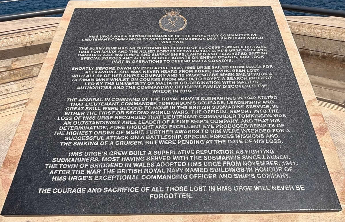 Legible close-up view of the bronze historical inscription panel mounted on top of the HMS Urge memorial