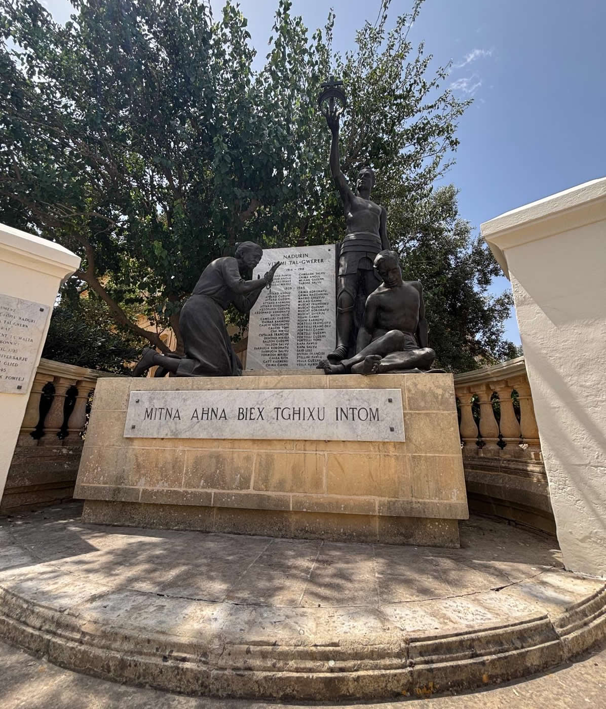Overall view of the Nadur War Memorial in Gozo featuring bronze sculptures and marble roll of honour