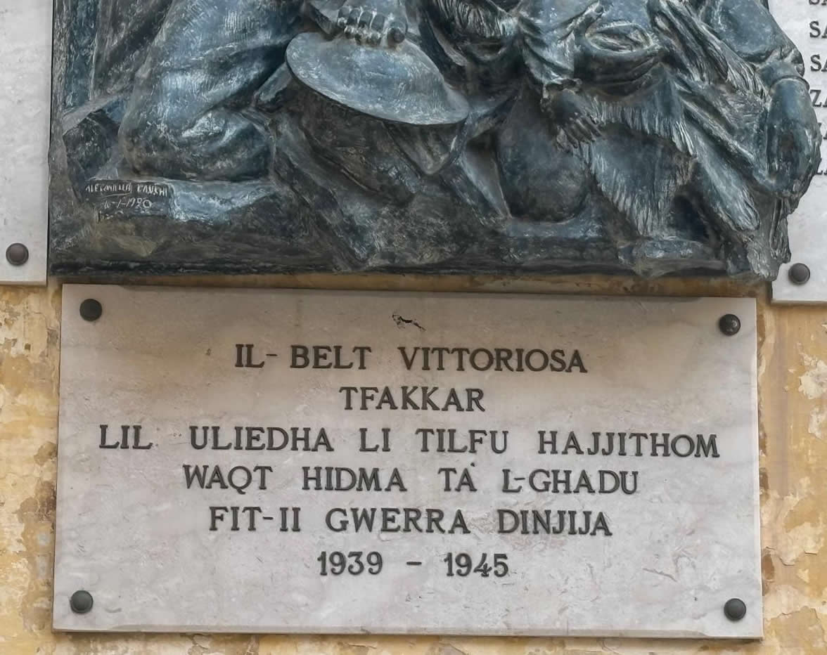 Close-up view of the base dedication plaque written in Maltese script honoring the wartime dead of Vittoriosa from 1939 to 1945.