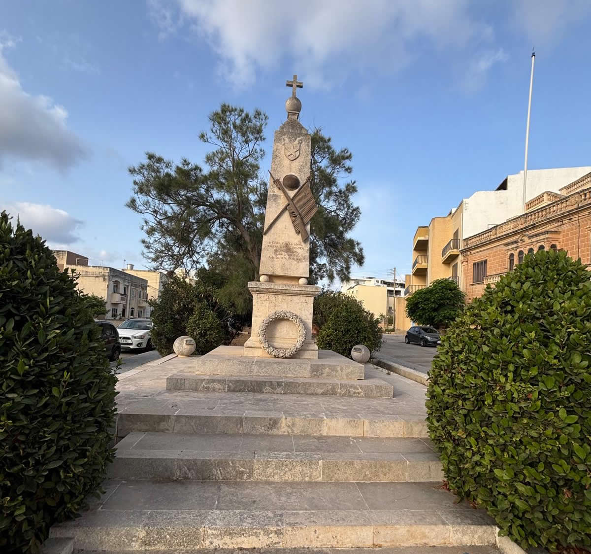 Overall view of the Qrendi War Memorial obelisk surmounted by a cross and sphere