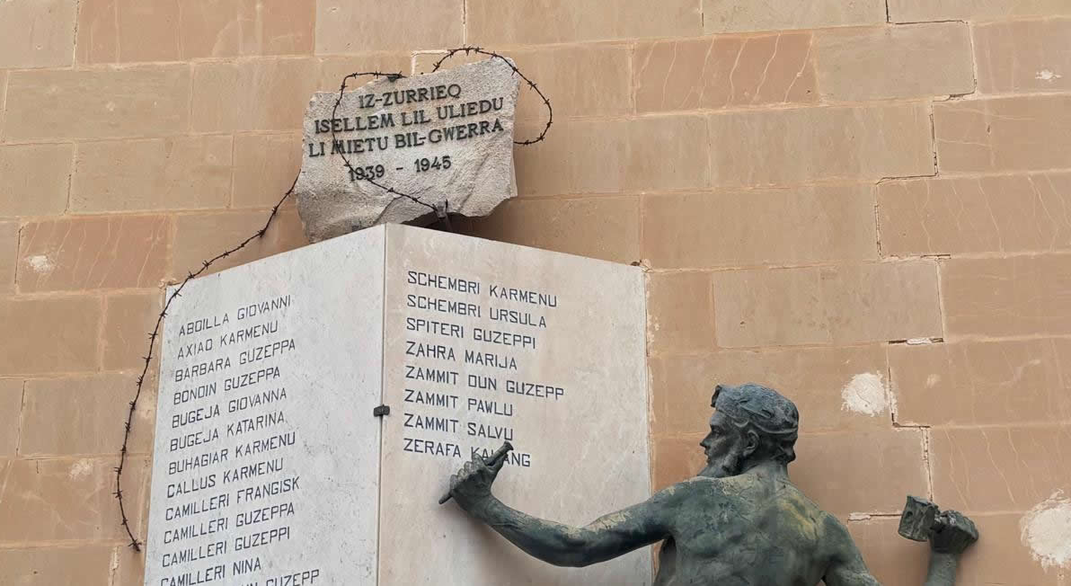 Close-up view of the top script plaque encased in barbed wire motif on the Żurrieq War Memorial